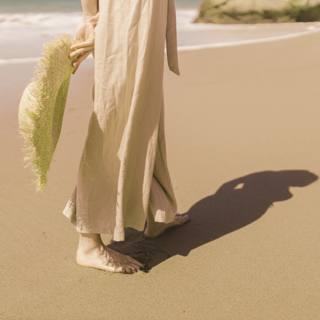 Woman standing on beach holding a leaf